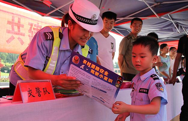 民警一边发放宣传资料,一边接受群众咨询