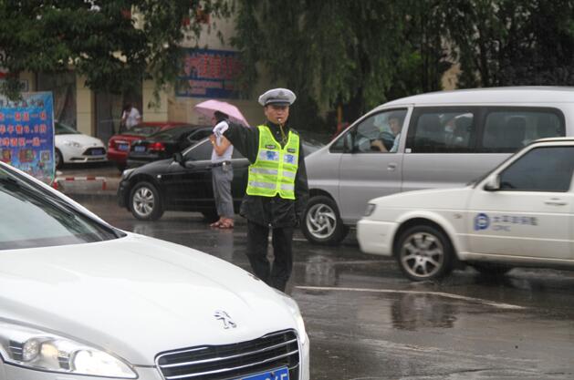 为市交警一大队民警冒雨疏导交通,确保市区道路安全畅通。 刘丹丹 摄