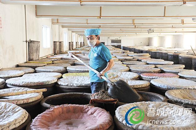 图为公司员工正在进行翻醅操作,确保醋酸正常发酵。本报记者 张文庭 摄