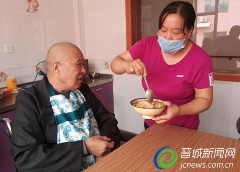 护理员给老人喂饭。