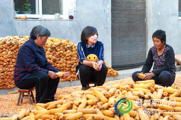 图为樊飞飞(中)在与村民交谈,了解生产、收入等情况。本报记者 豆晓军 摄