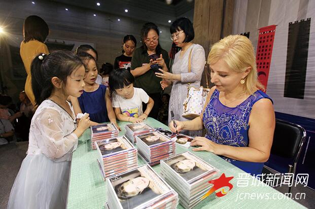乔安娜为现场小琴迷签售了自己的成名CD。