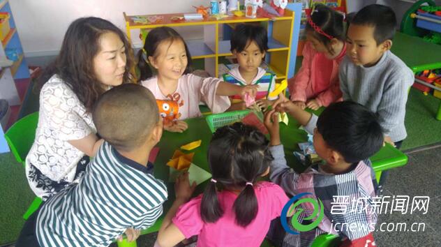 原喆芳在幼儿园和孩子们做互动游戏。