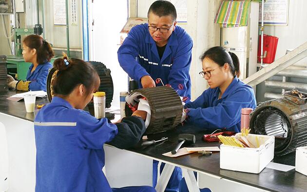 图为胡清连(中)在工作室指导学员进行技术攻关。